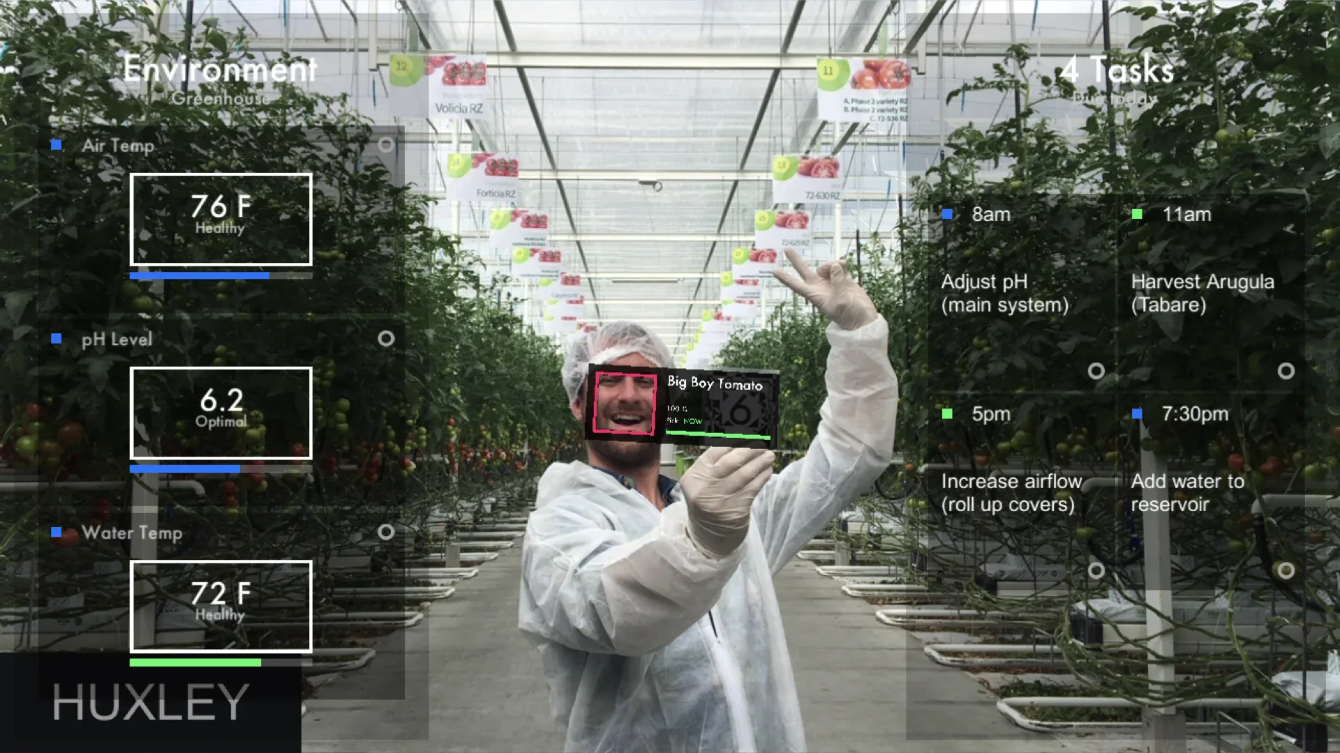 Researcher in a greenhouse with augmented environmental readings